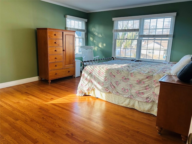 bedroom with crown molding and light wood-type flooring