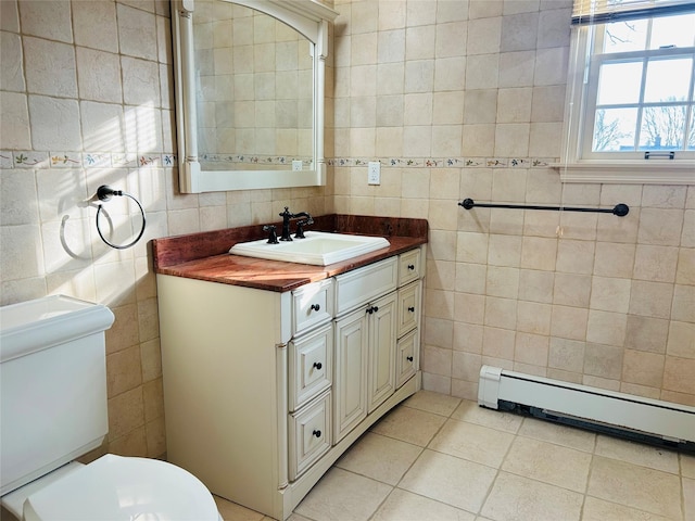 bathroom featuring tile walls, tile patterned flooring, vanity, baseboard heating, and toilet