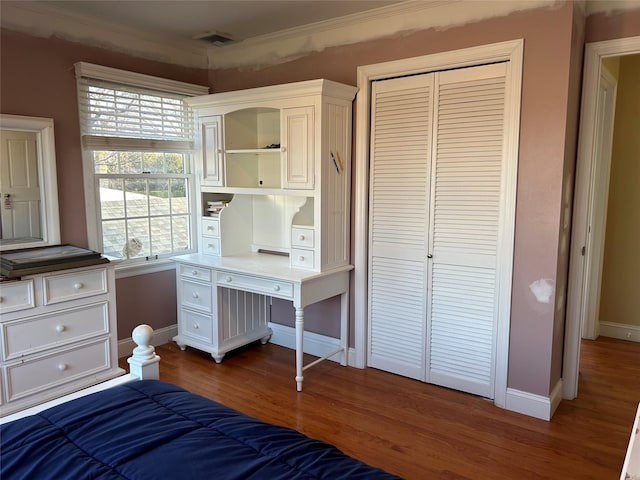 unfurnished bedroom featuring a closet, ornamental molding, and dark hardwood / wood-style floors