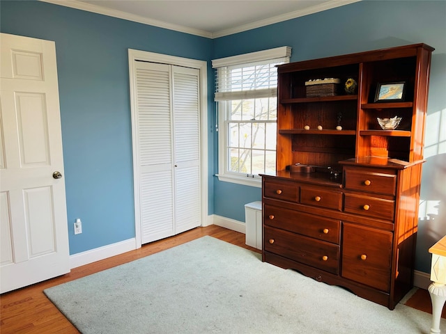 bedroom featuring crown molding, light hardwood / wood-style floors, and a closet