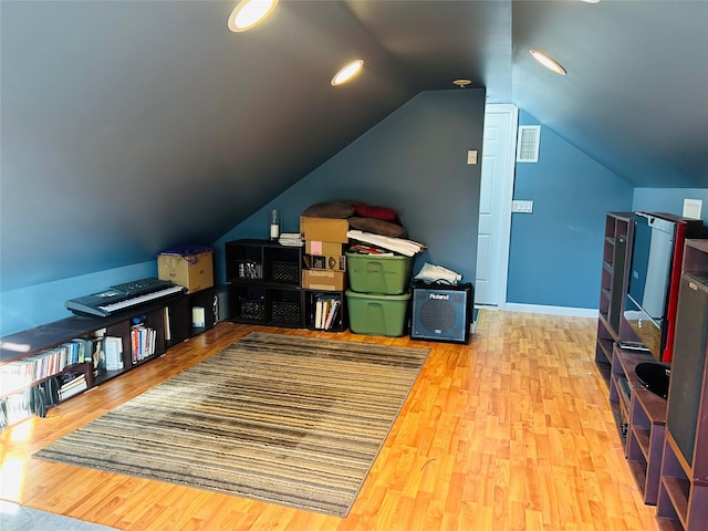 additional living space with lofted ceiling and hardwood / wood-style floors