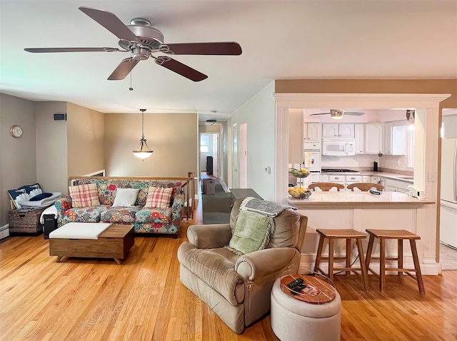 living room featuring ceiling fan and light hardwood / wood-style floors