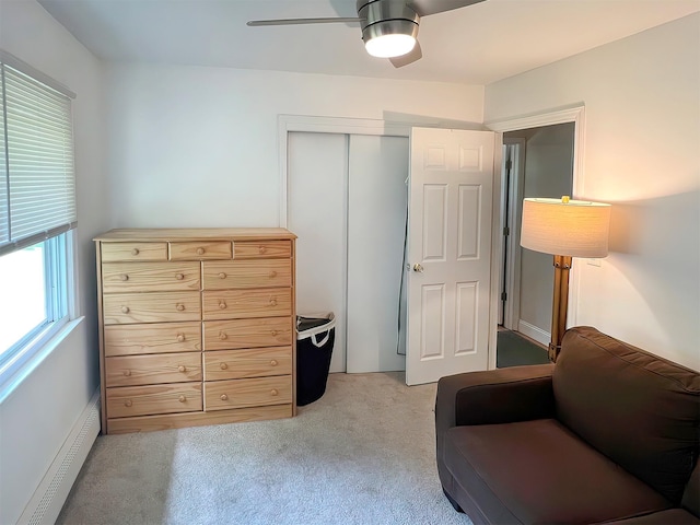 sitting room featuring ceiling fan, light colored carpet, and a baseboard heating unit