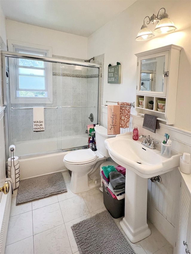 bathroom with toilet, tile patterned flooring, and enclosed tub / shower combo