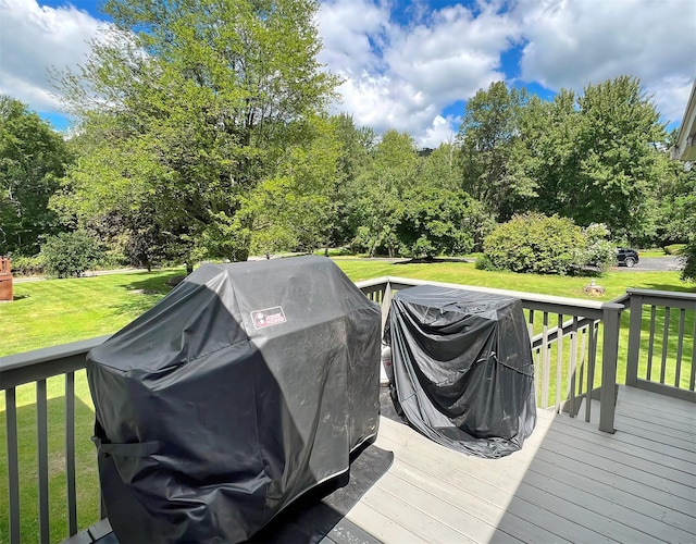 wooden terrace with a yard and grilling area