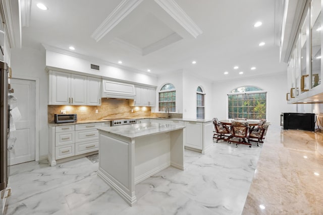 kitchen featuring white cabinets, a center island, range, and light stone counters