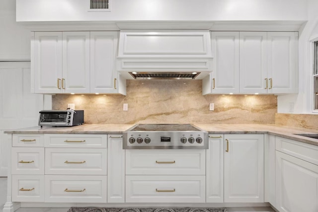 kitchen with white cabinets, stainless steel gas cooktop, and tasteful backsplash