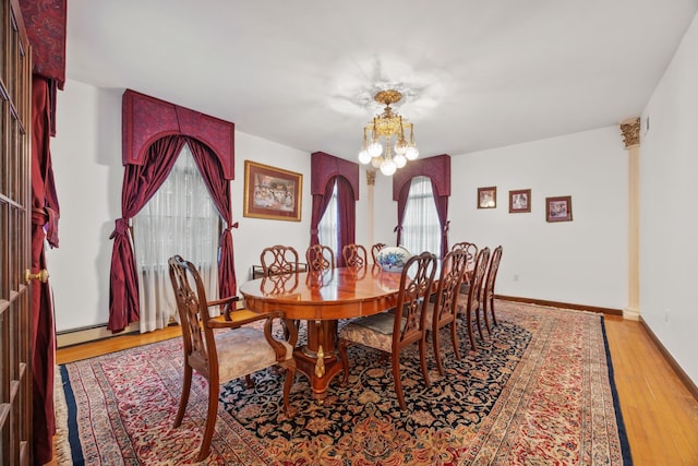 dining area with light wood-type flooring and a notable chandelier