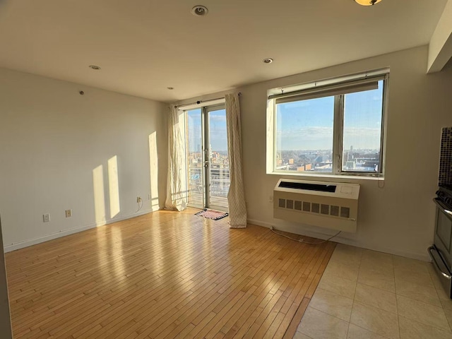 unfurnished room featuring heating unit and a wall mounted air conditioner