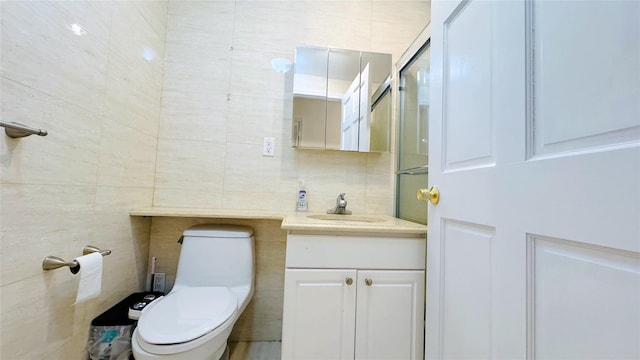 bathroom with tile walls, toilet, and vanity