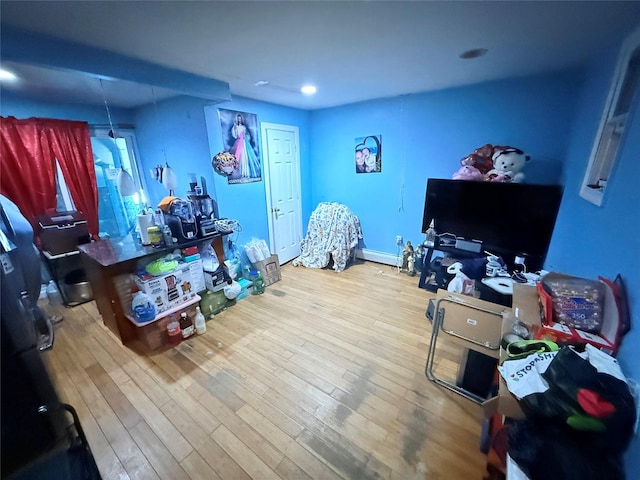 bedroom featuring baseboard heating and hardwood / wood-style flooring