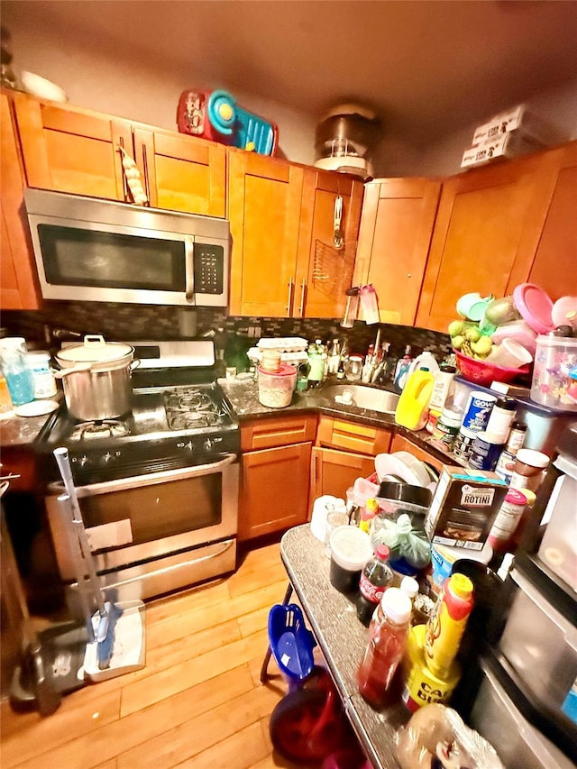 kitchen featuring light hardwood / wood-style floors, stainless steel appliances, and sink