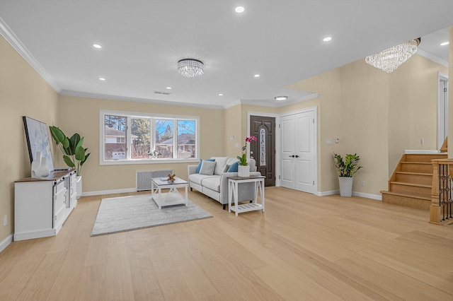 living room with a chandelier, light hardwood / wood-style floors, and ornamental molding