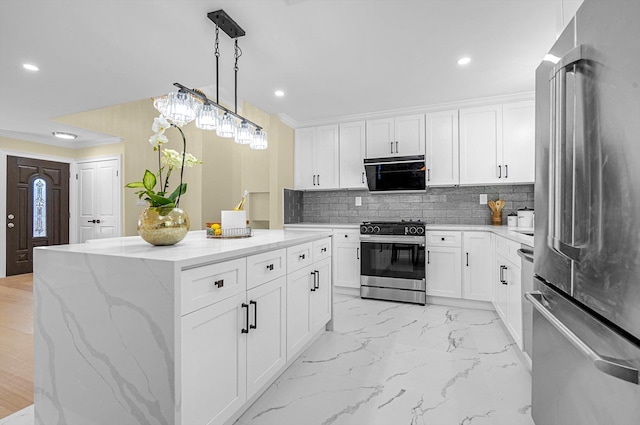 kitchen with white cabinets, appliances with stainless steel finishes, a center island, decorative backsplash, and hanging light fixtures