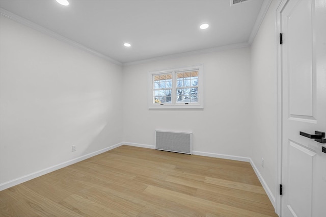 empty room with crown molding and light wood-type flooring