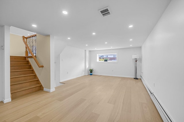 unfurnished living room with light wood-type flooring and a baseboard radiator