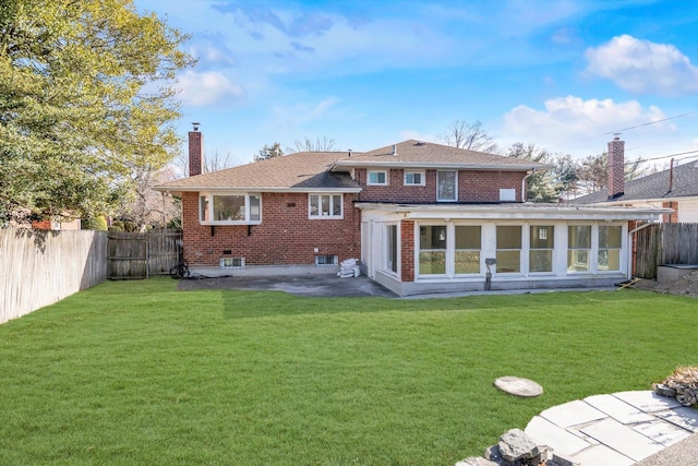 back of house featuring a sunroom, a lawn, and a patio