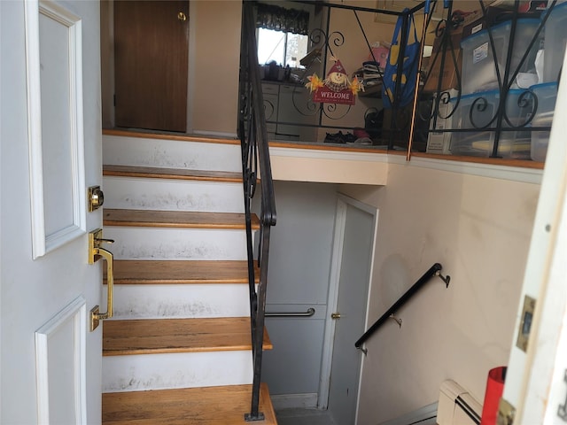 staircase with a baseboard heating unit