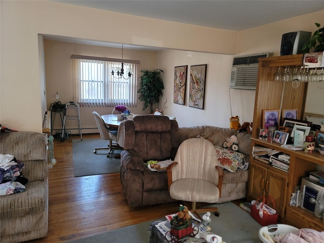 living room with a baseboard heating unit, a wall unit AC, a notable chandelier, and wood finished floors