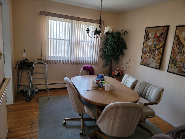 dining area with a baseboard radiator, wood finished floors, and an inviting chandelier