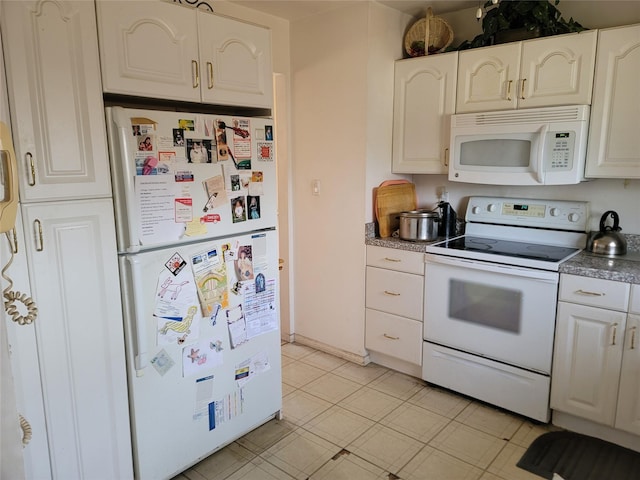 kitchen with dark countertops, white appliances, and white cabinetry