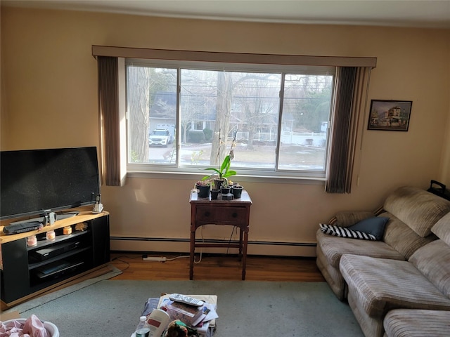 living area with a baseboard heating unit and wood finished floors