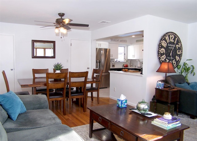 living room with light wood-type flooring and ceiling fan