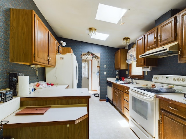 kitchen with white appliances, lofted ceiling with skylight, a wealth of natural light, and sink