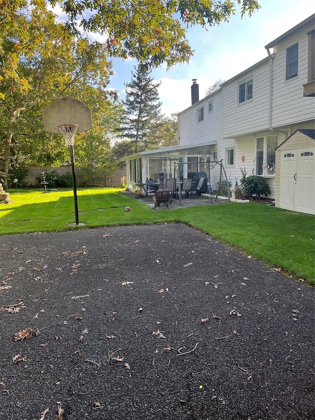 rear view of house featuring a shed, a patio area, and a lawn