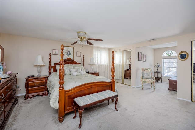 carpeted bedroom featuring multiple windows and ceiling fan