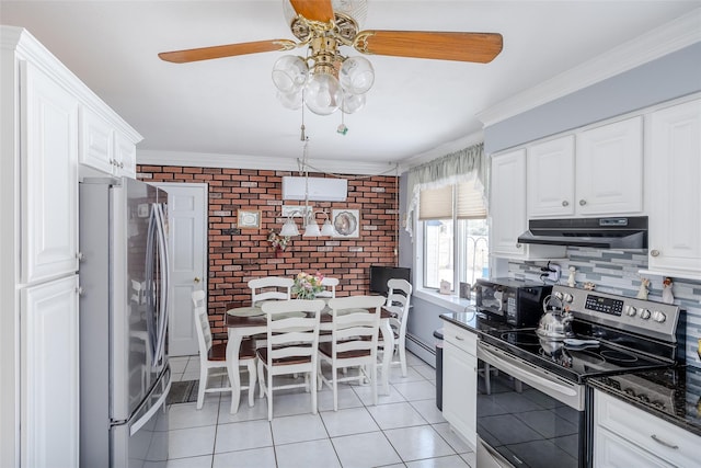 kitchen with light tile patterned floors, appliances with stainless steel finishes, white cabinetry, ornamental molding, and brick wall