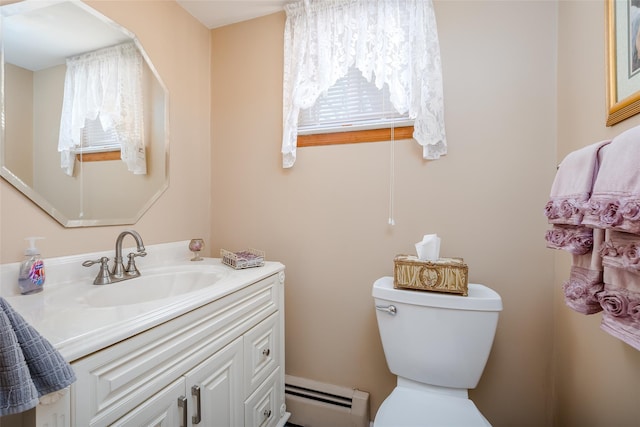 bathroom with vanity, toilet, and a baseboard heating unit