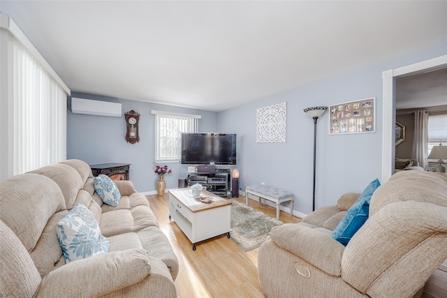 living room featuring a wall unit AC and light hardwood / wood-style flooring