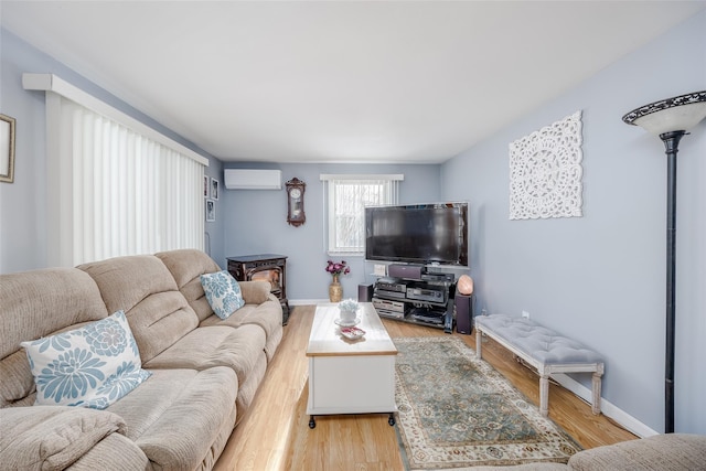 living room featuring a wall mounted air conditioner and light wood-type flooring