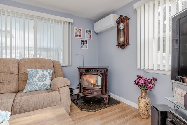 living area featuring hardwood / wood-style flooring, plenty of natural light, a wall mounted AC, and a wood stove