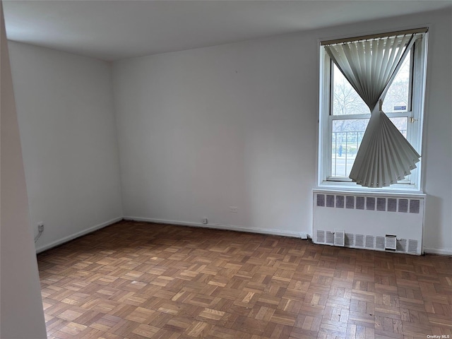 unfurnished room featuring radiator heating unit and parquet floors