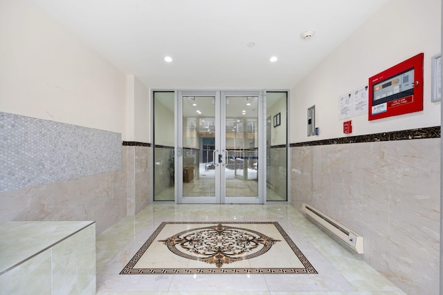 entrance to property featuring a baseboard heating unit and french doors