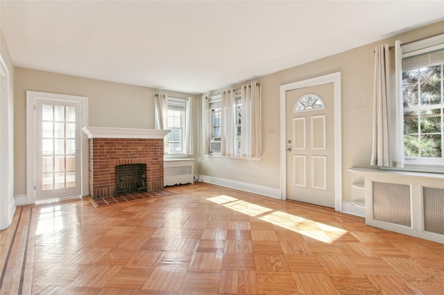 53 S Grove St S, Valley Stream, NY 11580 - unfurnished living room featuring cooling unit, a brick fireplace, radiator heating unit, and light parquet flooring