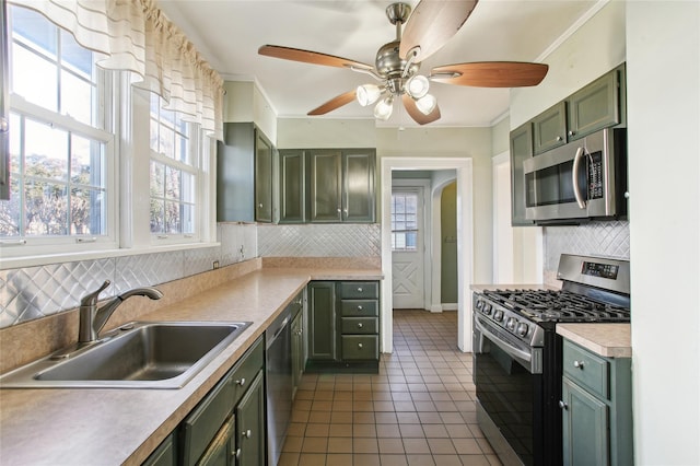 53 S Grove St S, Valley Stream, NY 11580 - kitchen featuring appliances with stainless steel finishes, a healthy amount of sunlight, green cabinetry, dark tile patterned floors, and sink