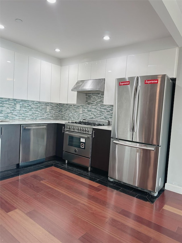 kitchen featuring dark hardwood / wood-style flooring, stainless steel appliances, tasteful backsplash, and white cabinetry