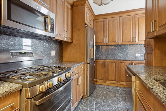 kitchen with tasteful backsplash, dark stone countertops, and stainless steel appliances