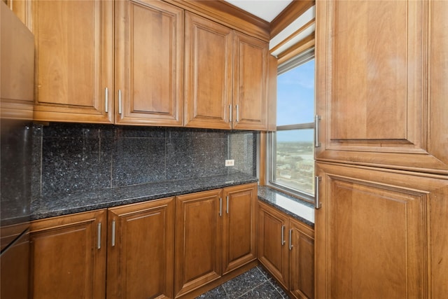 kitchen with a healthy amount of sunlight, backsplash, and dark stone countertops