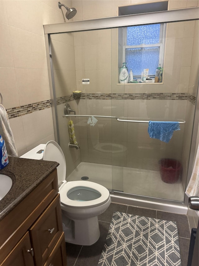 bathroom with toilet, an enclosed shower, tile patterned flooring, and vanity