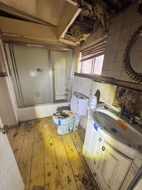 interior space featuring vanity, wood-type flooring, and enclosed tub / shower combo