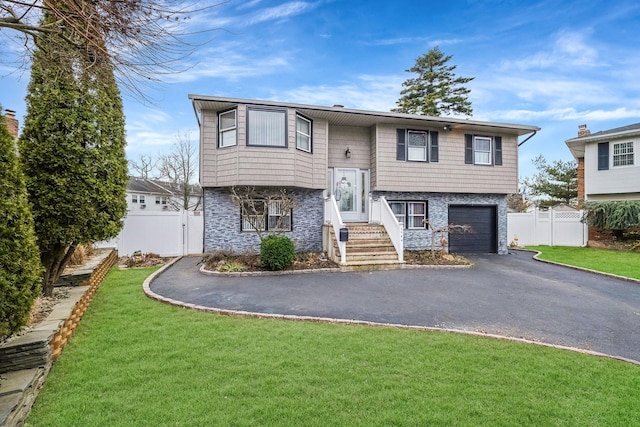 bi-level home featuring a front lawn and a garage