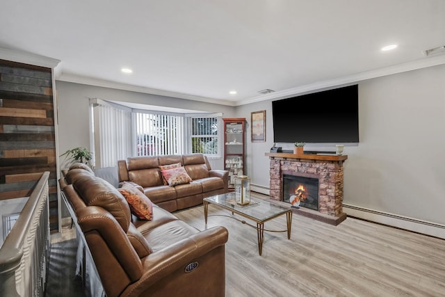 living room with baseboard heating, a stone fireplace, and crown molding