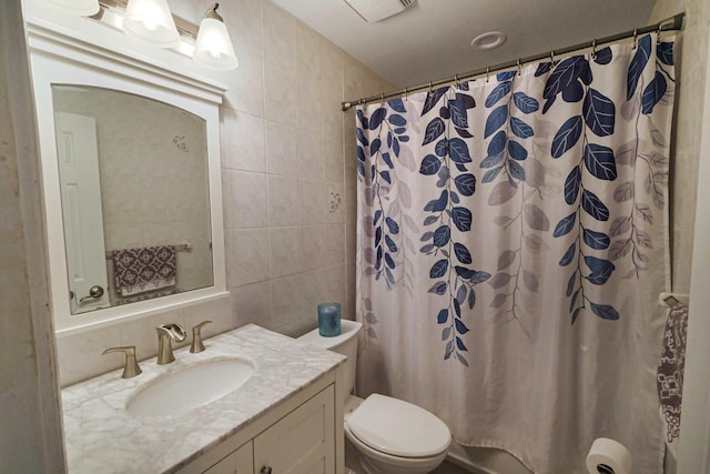 bathroom featuring curtained shower, tile walls, toilet, and vanity