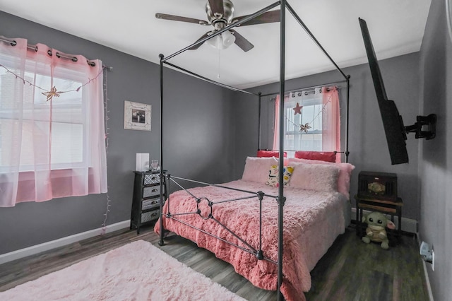 bedroom with ceiling fan, multiple windows, and hardwood / wood-style flooring