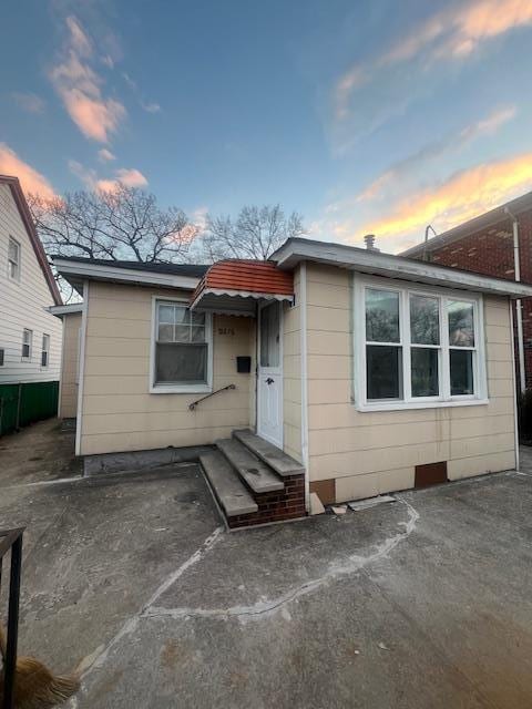 back house at dusk featuring a patio area