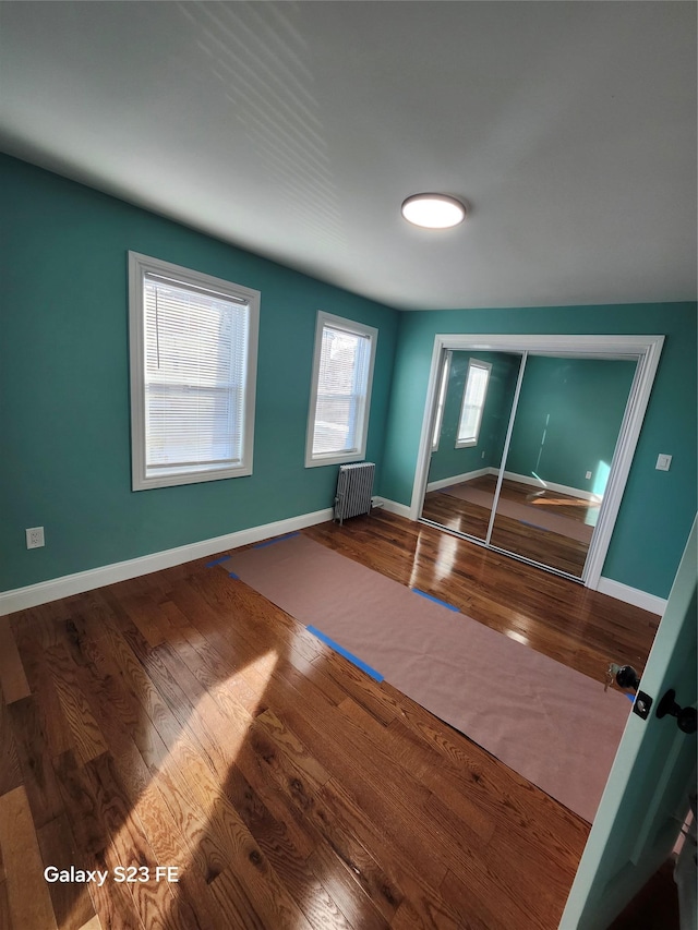 interior space featuring radiator heating unit and hardwood / wood-style flooring